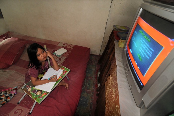 BELAJAR MELALUI STREAMING DI RUMAH Seorang murid sekolah dasar (SD) belajar melalui siaran streaming TVRI di rumahnya, di Padang, Sumatera Barat, Senin (13/4/2020). Kemendikbud resmi meluncurkan program