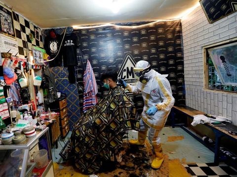 Tukang cukur di Bogor kerja pakai baju hazmat.