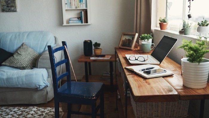 Cropped shot of technology and a notebook on a desk in an empty home office during the day