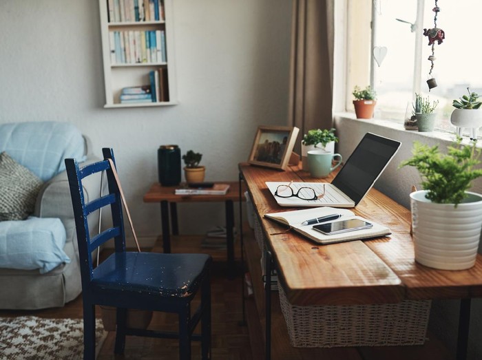 Cropped shot of technology and a notebook on a desk in an empty home office during the day