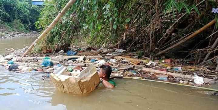 Wahyudi saat mengangkut sampah di sungai (dok. Istimewa)