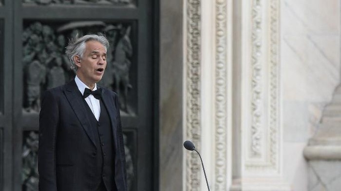 Italian tenor and opera singer Andrea Bocelli sings during a rehearsal on a deserted Piazza del Duomo in central Milan on April 12, 2020, prior to an evening performance without public for the world wounded by the pandemic, during the countrys lockdown aimed at curbing the spread of the COVID-19 infection, caused by the novel coronavirus. (Photo by Piero Cruciatti / AFP)