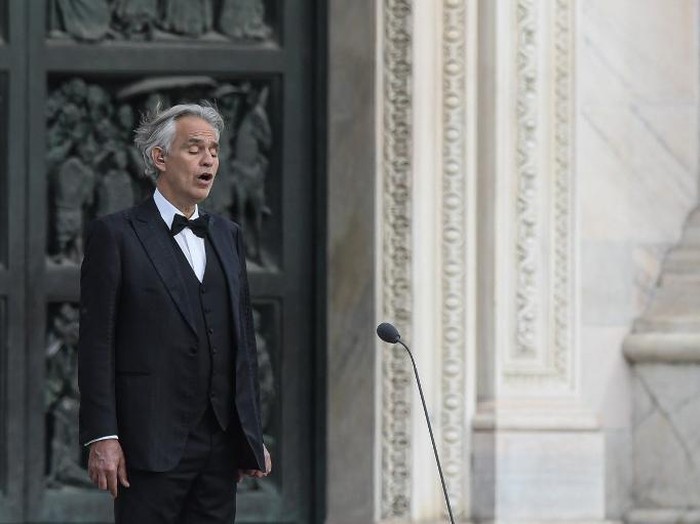 Italian tenor and opera singer Andrea Bocelli sings during a rehearsal on a deserted Piazza del Duomo in central Milan on April 12, 2020, prior to an evening performance without public for the world wounded by the pandemic, during the countrys lockdown aimed at curbing the spread of the COVID-19 infection, caused by the novel coronavirus. (Photo by Piero Cruciatti / AFP)