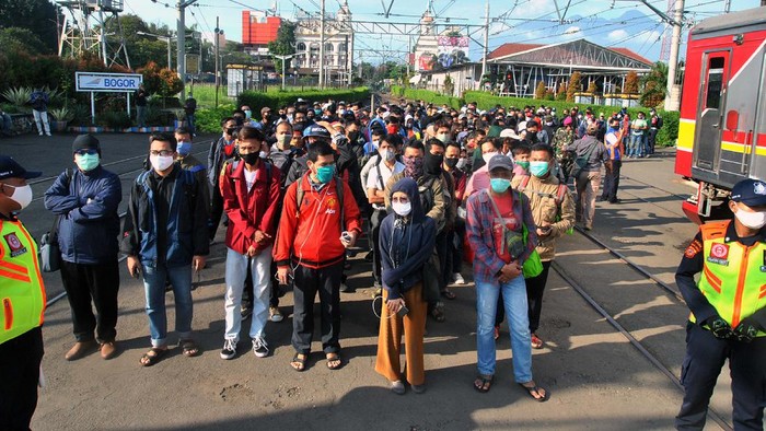ANTREAN PENUMPANG KRL Sejumlah penumpang KRL Commuter Line antre menunggu kedatangan kereta di Stasiun Bogor, Jawa Barat, Senin (13/4/2020). Antrean panjang penumpang KRL Commuter Line di Stasiun Bogor tersebut akibat kebijakan pemeriksaan suhu tubuh dan pembatasan jumlah penumpang di setiap rangkaian kereta sebagai tindakan pencegahan penyebaran wabah pandemi virus Corona (COVID-19). ANTARA FOTO/Arif Firmansyah/hp.