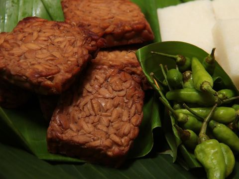 Tempe Bacem, the traditional Javanese dish of tempeh (soy bean cake) braised in soy sauce. A popular accompaniment for many other Javanese dish, such as with Jadah, the glutinous rice and coconut cake. The dish are placed on a woven bamboo tray lined with banana leaf. Jadah tempe are eaten with fresh green chili pepper.