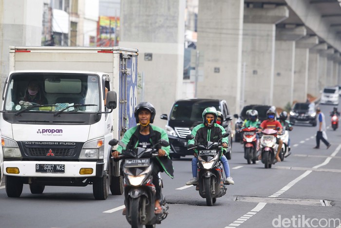 Ojek online kembali tengah menarik penumpang di kawasan Jakarta Selatan, Senin (13/4/2020). Kementerian Perhubungan mengizinkan ojek online (ojol) untuk kembali mengangkut penumpang wilayah yang menerapkan PSBB.