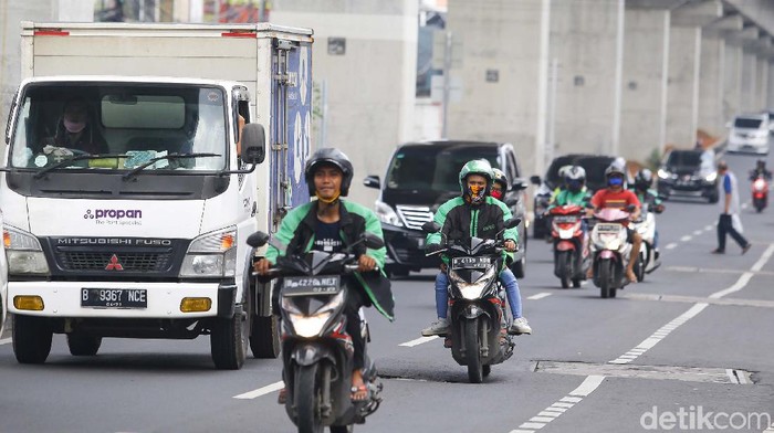 Ojek online kembali tengah menarik penumpang di kawasan Jakarta Selatan, Senin (13/4/2020). Kementerian Perhubungan mengizinkan ojek online (ojol) untuk kembali mengangkut penumpang wilayah yang menerapkan PSBB.