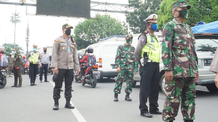 Polisi menyetop kendaraan di cek poin PSBB Kalideres, Jakbar