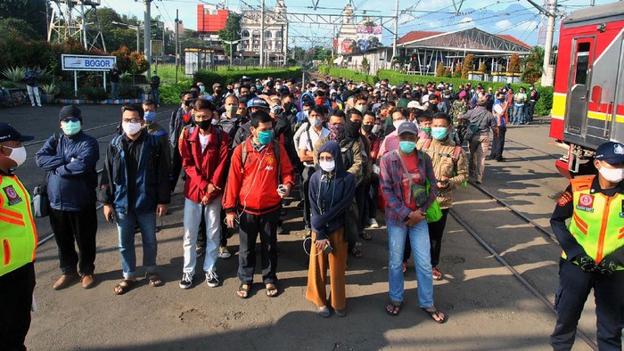 Sejumlah penumpang KRL Commuter Line antre menunggu kedatangan kereta di Stasiun Bogor, Jawa Barat, Senin (13/4/2020). Antrean panjang penumpang KRL Commuter Line di Stasiun Bogor tersebut akibat kebijakan pemeriksaan suhu tubuh dan pembatasan jumlah penumpang di setiap rangkaian kereta sebagai tindakan pencegahan penyebaran wabah pandemi virus Corona (COVID-19). ANTARA FOTO/Arif Firmansyah/hp.