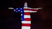 Begini penampakan Patung Kristus yang terlihat menganakan pakaian dengan motif bendera Amerika Serikat di Rio de Janeiro, Brasil.