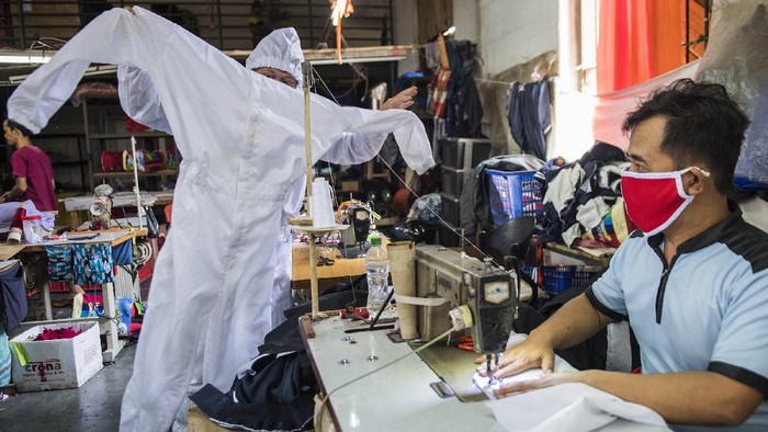 Penjahit memakai contoh pakaian alat pelindung diri (APD) untuk tenaga medis di Bandung, Jawa Barat, Senin (13/4/2020). Penjahit spesialis seragam dinas dan jaket ini mengalihkan produksinya ke pembuatan APD untuk tenaga medis dalam penanganan pasien COVID-19 di sejumlah rumah sakit umum dan swasta di Jawa Barat dengan jumlah produksi 300 hingga 400 buah per minggu. ANTARA FOTO/M Agung Rajasa/wsj.