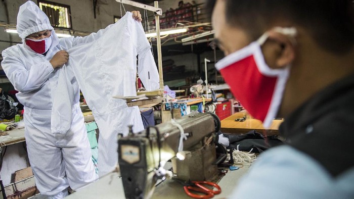Penjahit memakai contoh pakaian alat pelindung diri (APD) untuk tenaga medis di Bandung, Jawa Barat, Senin (13/4/2020). Penjahit spesialis seragam dinas dan jaket ini mengalihkan produksinya ke pembuatan APD untuk tenaga medis dalam penanganan pasien COVID-19 di sejumlah rumah sakit umum dan swasta di Jawa Barat dengan jumlah produksi 300 hingga 400 buah per minggu. ANTARA FOTO/M Agung Rajasa/wsj.