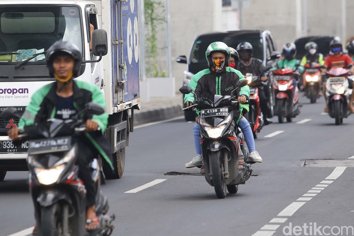Ojek online kembali tengah menarik penumpang di kawasan Jakarta Selatan, Senin (13/4/2020). Kementerian Perhubungan mengizinkan ojek online (ojol) untuk kembali mengangkut penumpang wilayah yang menerapkan PSBB.