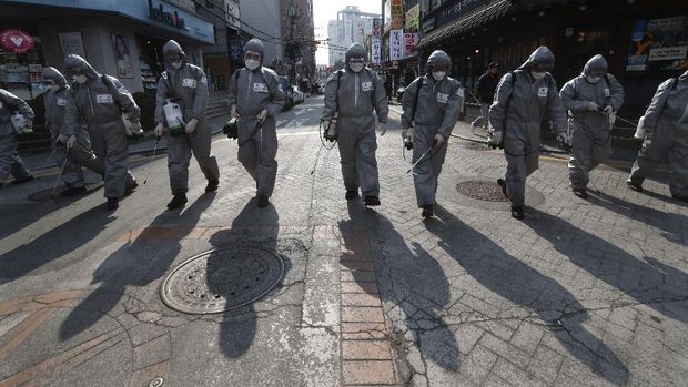 South Korean army soldiers wearing protective gears spray disinfectant as a precaution against the new coronavirus at a shopping street in Seoul, South Korea, Wednesday, March 4, 2020. The coronavirus epidemic shifted increasingly westward toward the Middle East, Europe and the United States on Tuesday, with governments taking emergency steps to ease shortages of masks and other supplies for front-line doctors and nurses. (AP Photo/Ahn Young-joon)