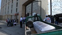 Sebuah mobil pickup mengangkut peti jenazah yang dibungkus plastik menuju pemakaman di Guayaquil. 