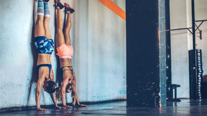 handstand Women performing handstand in gym. Professional sportists. Wearing sports clothing.
