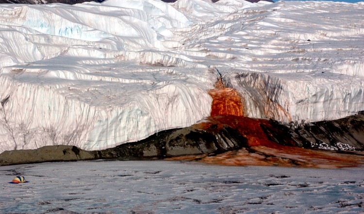 Air Terjun Darah di Antartika juga menjadi salah satu destinasi wisata populer bagi pencinta wisata horor dan misterius. Warna air yang berwarna merah seperti darah jadi salah satu daya tarik bagi para wisatawan untuk datang berkunjung dan melihat langsung air terjun tersebut. Istimewa/Dok. Wikipedia/National Science Foundation/Peter Rejcek.