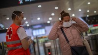 Mulai Senin (13/4), para buruh pabrik telah diizinkan untuk kembali bekerja. Pihak kepolisian Spanyol juga membagikan masker pelindung wajah secara cuma-cuma di sejumlah stasiun kereta. AP Photo/Emilio Morenatti.