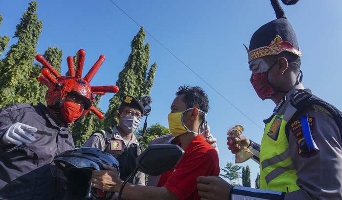 POLISI GUNAKAN KOSTUM PUNOKAWAN BAGI MASKER Petugas Satlantas Polres Pekalongan Kota menggunakan kostum punokawan membagi masker kepada pengguna jalan saat operasi simpatik pembagian masker di Pekalongan, Jawa Tengah, Selasa (14/4/2020). Selain menghimbau pencegahan wabah virus Corona (COVID-19), Satlantas Polres Pekalongan Kota juga membagikan 2.000 masker gratis kepada pengguna jalan yang tidak menggunakan masker agar terhindar dari virus Corona. ANTARA FOTO/Harviyan Perdana Putra/foc.
