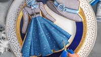 Liz Joy juga mampu membuat kreasi hiasan cookies gaun ala Kerajaan Inggris yang elegan dan anggun. Ditambah topi berwarna abu-abu dan sentuhan mawar biru di pinggirnya. Ia juga gunakan pewarna makanan untuk cookies buatannya tersebut. Foto: Instagram @inspiredtotaste