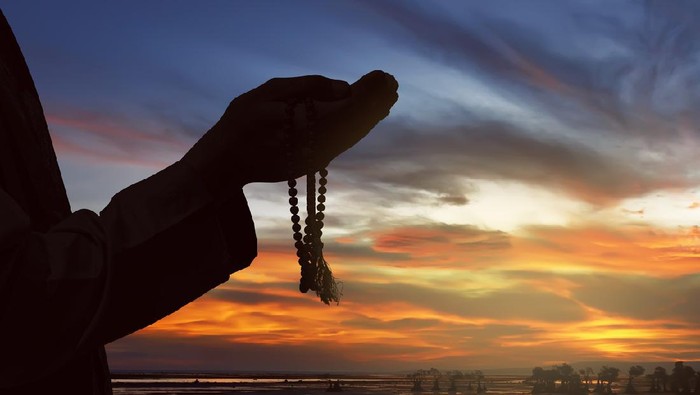 Image of silhouette hand man praying with sunset background