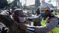 Petugas Satlantas Polres Pekalongan Kota yang tampil dengan menggunakan kostum punokawan membagi masker kepada pengguna jalan saat operasi simpatik pembagian masker di Pekalongan, Jawa Tengah, Selasa (14/4/2020).