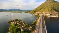 Selama 12 jam perjalanan, kereta menghilang ke Dinaric Alps, menyerbu melalui ngarai, bergoyang-goyang di jembatan-jembatan terjal yang membentang di jurang-jurang sungai, dan meluncur di atas sebuah danau tektonik kuno. Istimewa/Dok. Kekyalyaynen/Shutterstock/Lonely Planet.