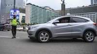 Polisi memberhentikan mobil berpenumpang yang melanggar aturan saat pemeriksaan kepatuhan Pembatasan Sosial Berskala Besar (PSBB) di kawasan Bundaran HI, Jakarta, Senin (13/4/2020).