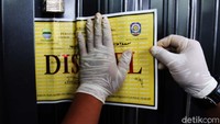 Petugas memasang kertas segel di depan akses pintu masuk ke gedung karaoke tersebut berada.