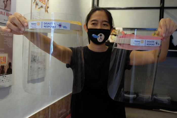 Relawan dari komunitas kreatif Mash Denpasar menunjukkan alat pelindung wajah berbahan plastik mika seusai proses produksi di Denpasar, Bali, Selasa (14/4/2020). Para relawan telah berhasil memproduksi sekitar 1.800 unit alat pelindung wajah dan didistribusikan secara sukarela untuk mendukung para petugas medis dalam penanganan COVID-19 di Bali. ANTARA FOTO/Nyoman Hendra Wibowo/nym/hp.