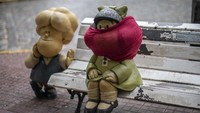Boneka Mafalda karakter kartun terkenal yang diciptakan oleh kartunis Argentina Joaquin Salvador Lavado, yang lebih dikenal sebagai Quino, duduk dengan wajah tertutup masker di Buenos Aires, Argentina, Senin (13/4/2020).