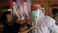 Seorang warga tengah memasangi pelindung wajah yang telah dibuatnya di Solo, Jawa Tengah untuk diuji cobakan. ANTARA FOTO/Maulana Surya