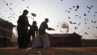 Para petugas tampak memberi makan burung merpati di Kuil Pashupatinath, Nepal, 31 Maret lalu. AP Photo/Niranjan Shrestha.