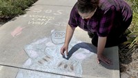 Lacey Gamble membuat mural dan simbol SOS di trotoar jalan untuk meminta bantuan.