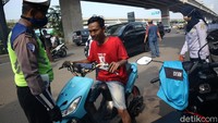Petugas menghentikan pengedara sepeda motor yang tidak mengenakan masker.