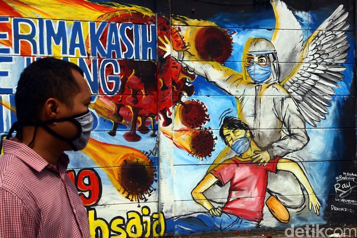 Mural Pejuang Medis Melawan Virus Corona Seorang warga melintas di dekat Mural perjuangan Tim Medis melawan Covid-19 di daerah Limo, Kota Depok, Jawa Barat, Rabu (15/4/2020). Mural itu sebagai ucapan terima kasih kapada tim medis yang menangani pasien Corona.