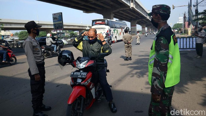 Petugas gabungan TNI, Polri, Dishub dan Satpol PP melakukan pemeriksaan cek point penerapan aturan Pembatasan Sosial Berskala Besar (PSBB) di Pasar Sumber Arta, Kalimalang, Kota Bekasi, Jawa Barat, Rabu (15/4/2020).
