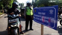 Petugas gabungan melakukan check point terhadap pengguna kendaraan di Bundaran Fly Over UI, Depok, Jawa Barat, Rabu (15/4/2020). Depok menerapkan Pembatasan Sosial Berskala Besar (PSBB) guna mencegah penyebaran virus Corona atau COVID-19.