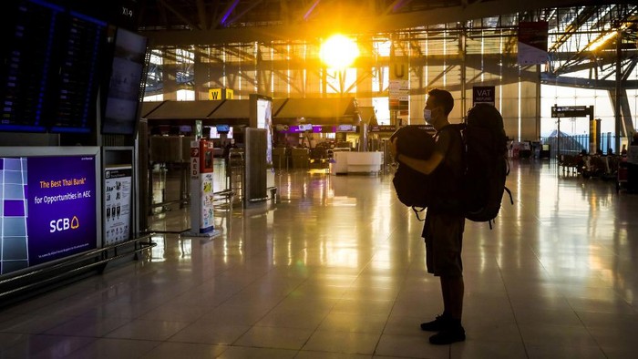 A passenger looks at a departure board in a nearly empty departure terminal at Suvarnabhumi Airport in Bangkok on April 3, 2020, as air travel in Thailand grinds to a near halt to prevent the spread of the COVID-19 novel coronavirus. (Photo by Vivek PRAKASH / AFP)
