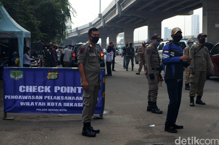 Penerapan PSBB Kota Bekasi Petugas gabungan TNI, Polri, Dishub dan Satpol PP melakukan pemeriksaan cek point penerapan aturan Pembatasan Sosial Berskala Besar (PSBB) di Pasar Sumber Arta, Kalimalang, Kota Bekasi, Jawa Barat, Rabu (15/4/2020).