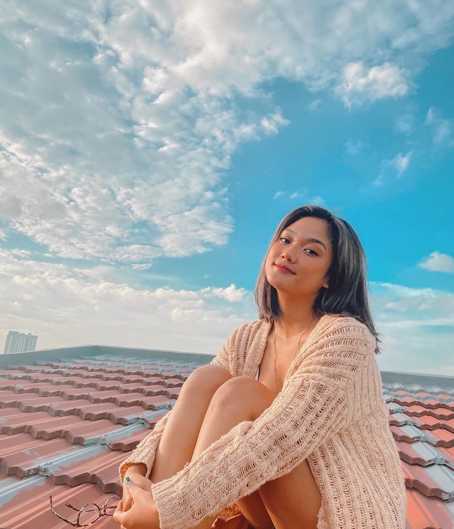 Penyanyi yang bernama lengkap Marion Rambu Jola Pedi atau yang lebih dikenal dengan nama Marion Jola, berjemur dengan tampil casual di atap rumahnya. Dia menggunakan cardigan rajut dan celana pendek. Foto: instagram @lalamarionmj