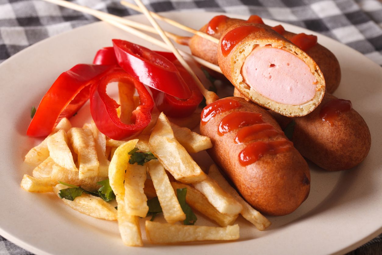 Mini Corn Dogs on stone platter with ketchup.