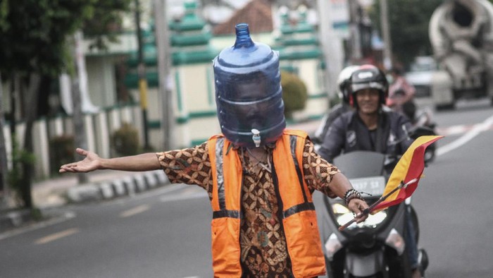 GUNAKAN GALON UNTUK PELINDUNG WAJAH Ali Akbar (52) Sukarelawan Pengatur Lalu Lintas (Supeltas) mengatur lalu lintas mengenakan pelindung wajah dari galon bekas di Jalan Tamansiswa, DI Yogyakarta, Rabu (15/4/2020). Ali Akbar menggunakan pelindung wajah unik itu saat mengatur lalu lintas guna mengantisipasi penularan COVID-19. ANTARA FOTO/Hendra Nurdiyansyah/foc.