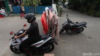 Warga yang ingin lewat harus melintasi jemuran warga yang menutup jalan terlebih dahulu.