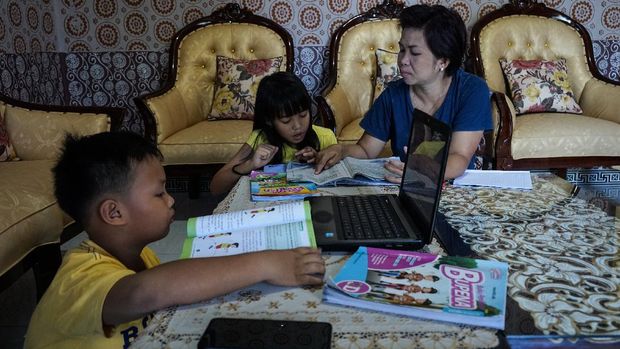 Siswa mengerjakan tugas didampingi ibunya dirumahnya, di  Palangkaraya, Kalimantan Tengah, Selasa (14/4/2020). Dinas Pendidikan Kalteng memperpanjang masa belajar dirumah dari 14 April 2020 menjadi 28 April 2020 mendatang untuk mencegah penyebaran COVID-19.