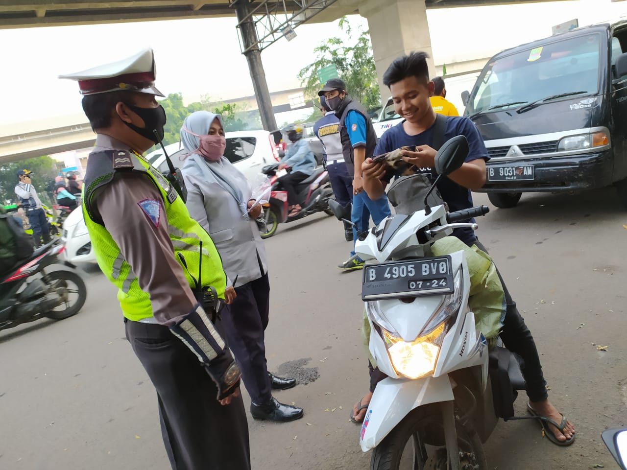 Pengendara ini padahal membai kain buff, tapi malah tidak digunakan. Polisi pun memberhentikannya.