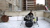 Musisi Farideh Sarsangi, 28, memainkan Drum di atap rumahnya.