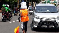 Dengan mengenakan rompi berwarna oranye, celana panjang warna hitam dan galon bekas di kepalanya, Ali tampak sibuk mengatur lalin di simpang 3 Jalan Tamansiswa, Kecamatan Mergangsan, Kota Yogyakarta.