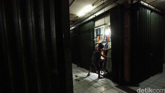 Seorang pedagang di Pasar Tambun, Kab Bekasi tengah menutup kiosnya, kini jam buka dan tutup pasar terdampak akibat peraturan PSBB terutama jam operasionalnya.