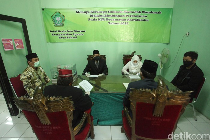 Prosesi Akad Nikah Sesuai Protokol COVID-19 Berbagai upaya untuk mencegah virus Corona dilakukan oleh sejumlah pihak. Salah satunya prosesi akad nikah yang dilakukan susai protokol pencegahan COVID-19.
